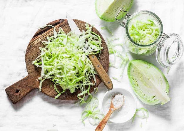 Cut cabbage on wooden chopping board on light background top view Vegetarian slimming diet