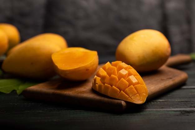 Cut and complete mangoes on the chopping board