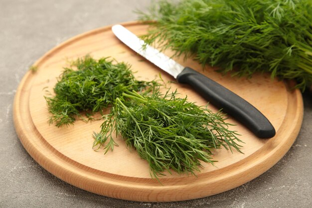 Cut dill on cutting board on grey background