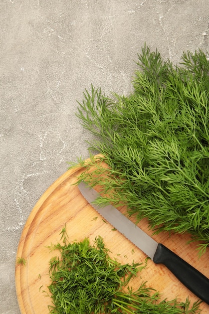 Cut dill on cutting board on grey concrete background Vertical photo