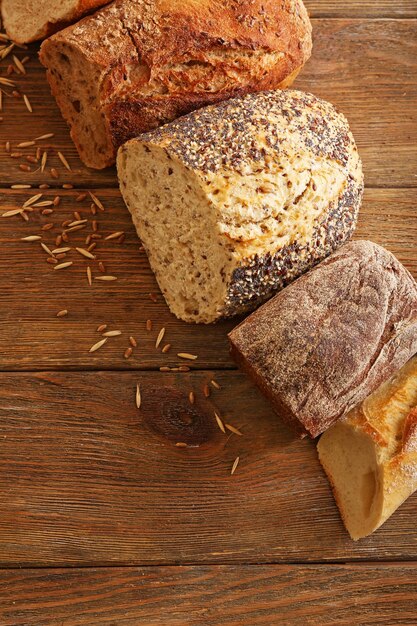 Cut fresh baked bread on the wooden background