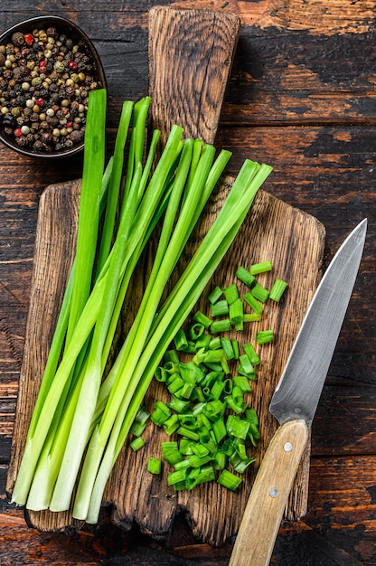 Cut Green onions chives on a cutting board.