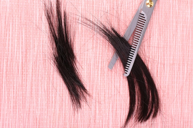 Cut hair and scissors on tile background