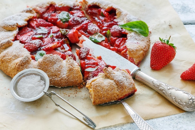 Cut homemade cake with strawberries and basil