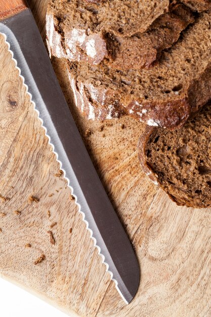 Cut into pieces delicious fresh loaf of bread, black rye bread divided into parts