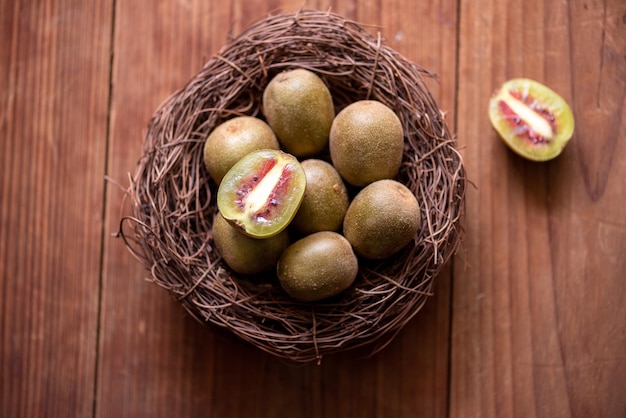 The cut kiwi fruit is placed on a plate on a wooden table