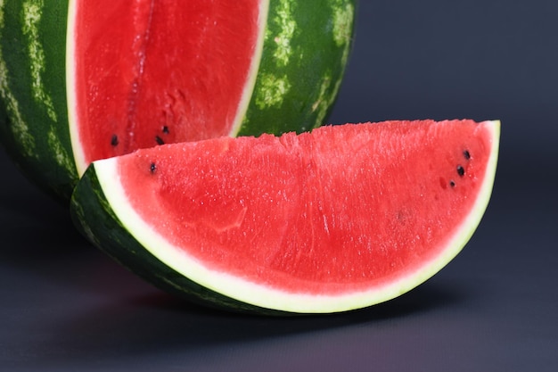 Cut pieces of red ripe delicious juicy watermelon on a black background