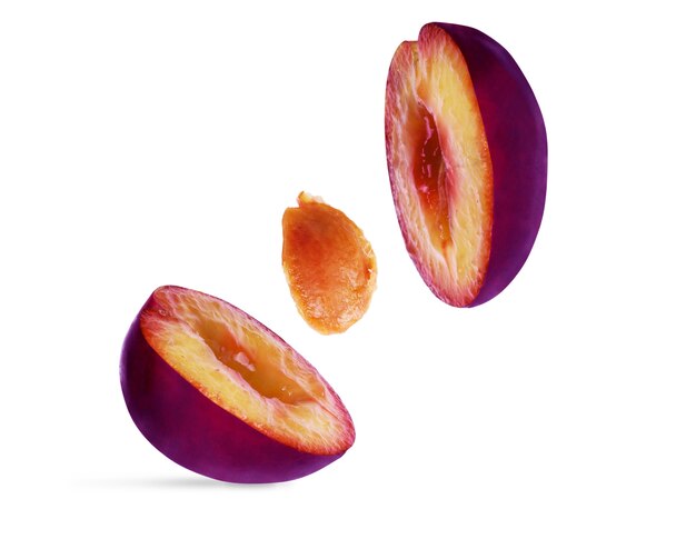 Cut plum in flight on a white background