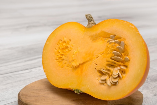 Cut pumpkin with seeds on a wooden board healthy foods