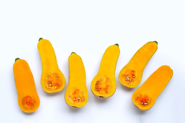 Cut and slices butternut squash on white background.