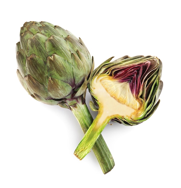 Cut and whole fresh artichokes on white background top view