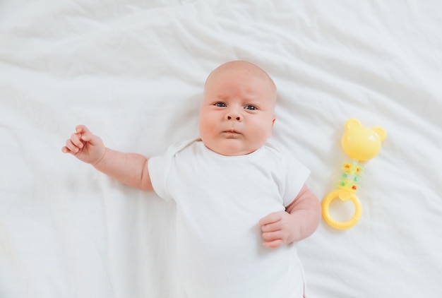 Cute 2monthold baby lying on the bed natural bed linen delicate baby skin