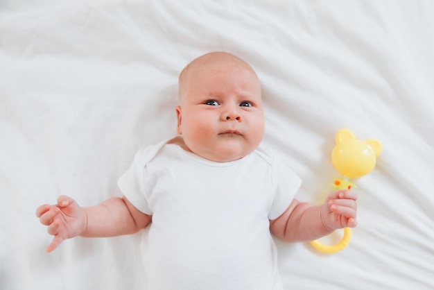 Cute 2monthold baby lying on the bed natural bed linen delicate baby skin