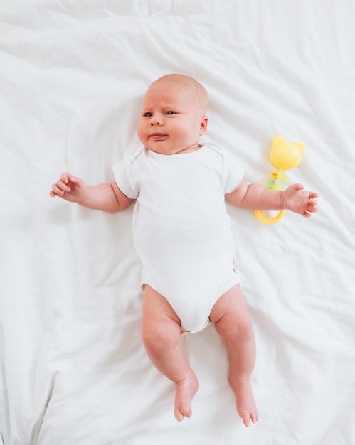 Cute 2monthold baby lying on the bed natural bed linen delicate baby skin