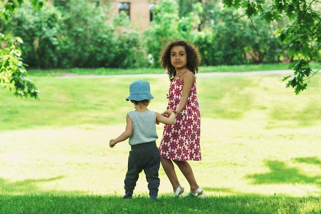 Cute  African girl and little caucasian boy in a city park