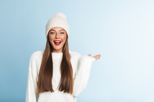 Cute amazing young woman wearing winter hat, showing copyspace.