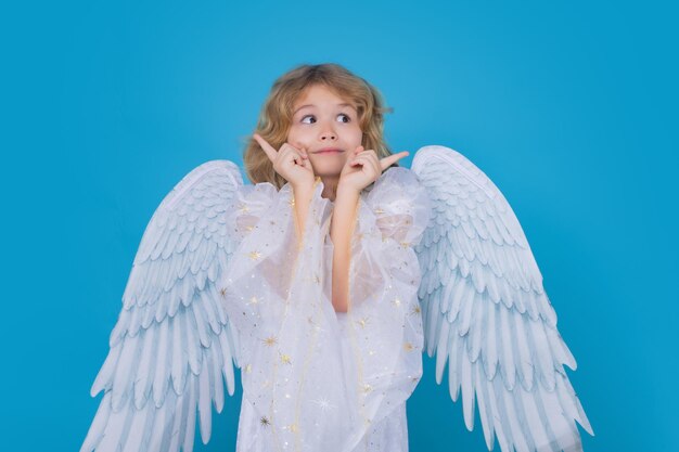 Cute angel kid studio portrait blonde curly little angel child with angels wings isolated background