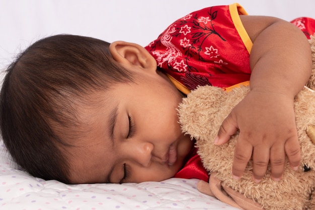 Cute asian baby in chinese traditional red dress sleeping