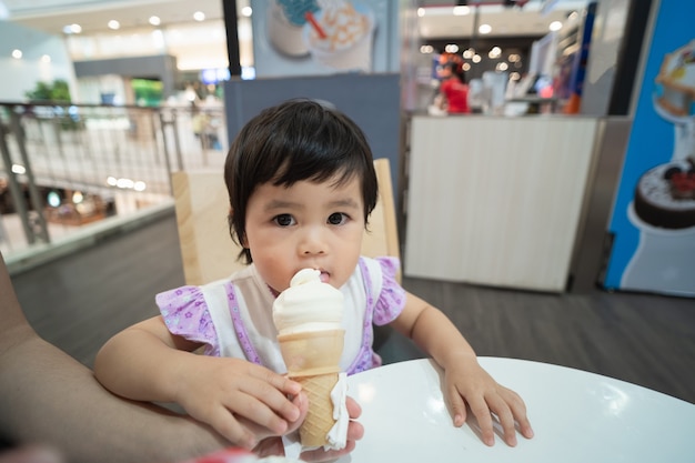 Cute asian baby eating ice cream in the restaurant