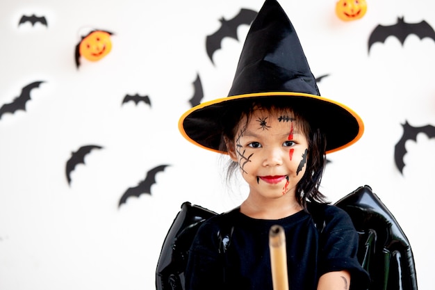 Cute asian child girl wearing halloween costumes and makeup having fun on Halloween celebration