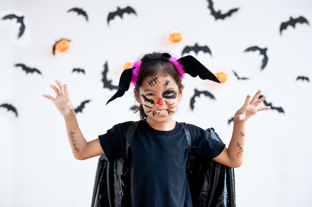 Cute asian child girl wearing halloween costumes and makeup having fun on Halloween celebration