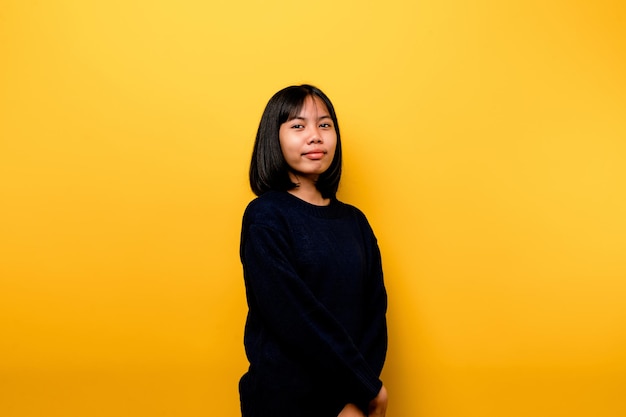 Cute Asian girl smiling on yellow background Empty young woman Place for advertisement copy space