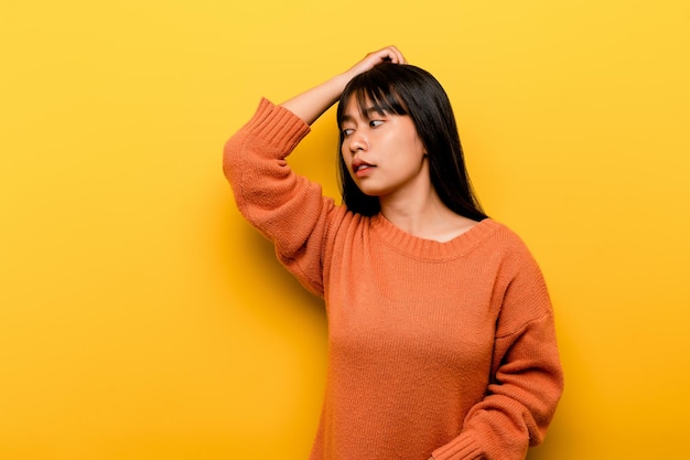 Cute Asian girl smiling on yellow background Empty young woman Place for advertisement copy space