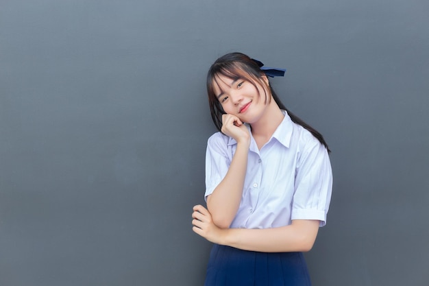 Cute Asian high school student girl in the school uniform with smiles confidently