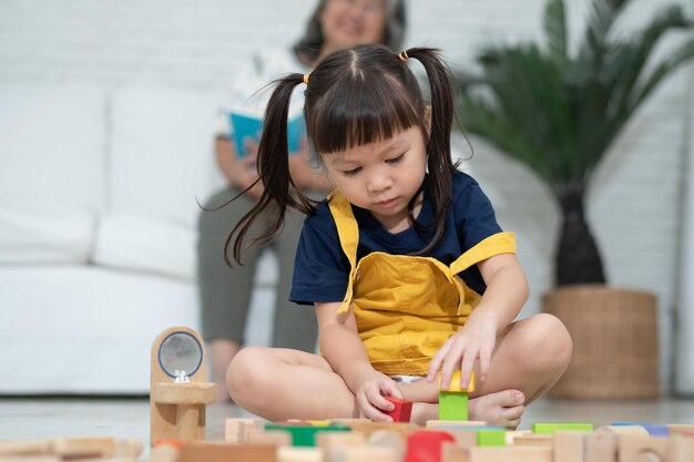 Cute asian little girl playing with colorful toy blocks Kids play with educational toys