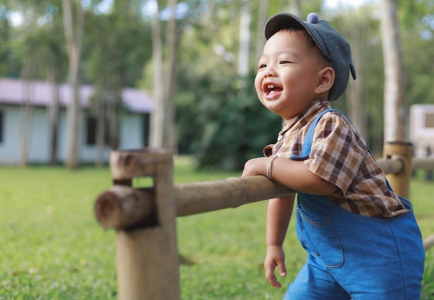 Cute Asian toddler boy playing in garden