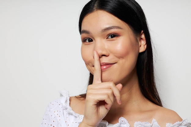 Cute asian woman in white shirt posing fashion light background