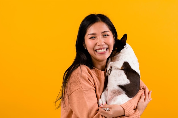 Cute Asian woman with his chihuahua chihuahua dog lover The happiness of a girl who loves his dog The love of people and cute dogs photo shoot in orange studio