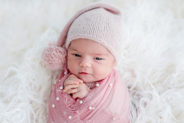 Cute awake newborn in knitted hat