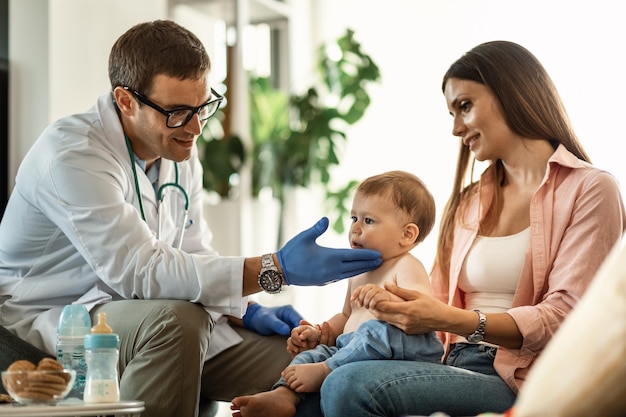 Cute baby boy and his mother during medical exam at pediatrician's office