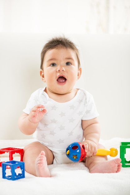 Cute baby boy sitting at home with toys