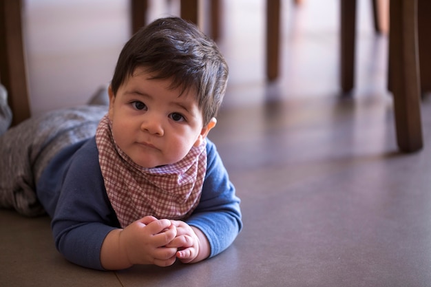 Cute baby boy under the table looking at the camera.