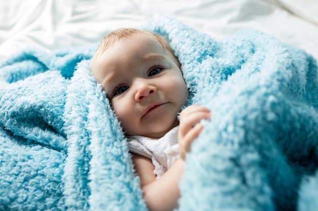 Cute baby girl lying on bed in bedroom