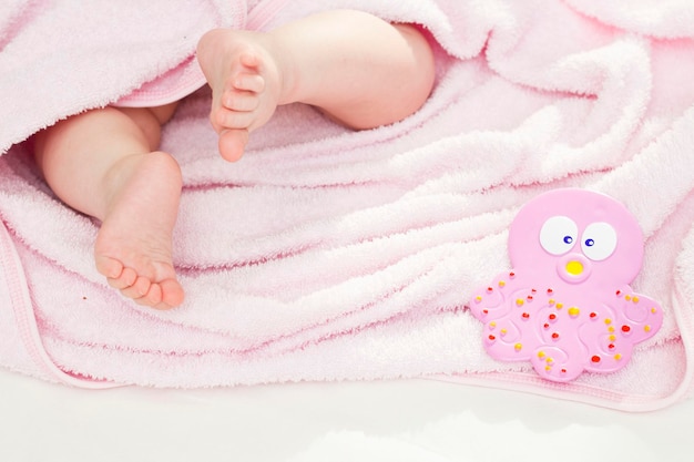 A cute baby is lying in a pink towel after a bath Bathing babies newborns