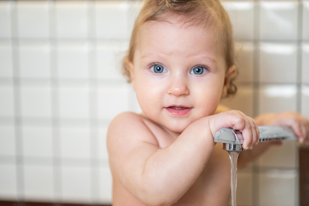 Cute baby playing in the kitchen sink