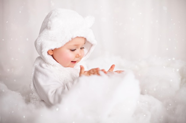 Cute baby playing with a cotton wool as artificial snow