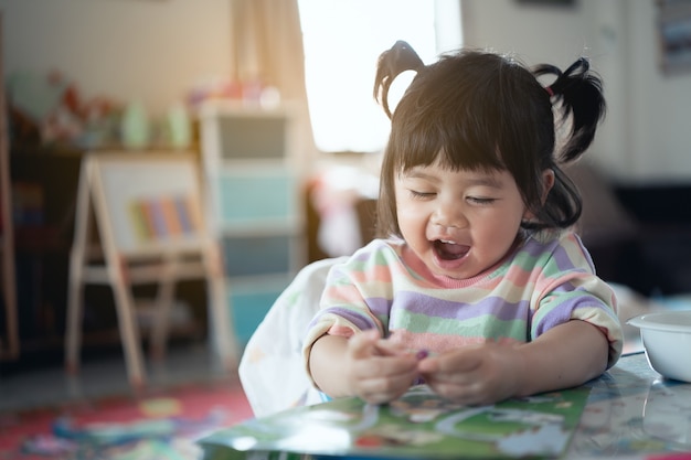 Cute baby smiling and laugh sitting on the chair in the house