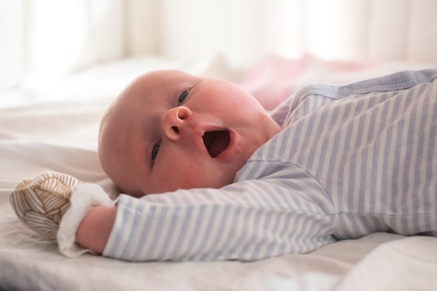 Cute baby yawns on a white background