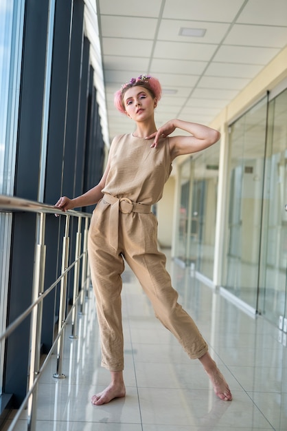 Cute barefoot woman standing inside building and looking forward