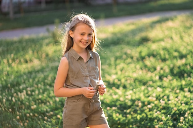 Cute beautiful little girl with crooked teeth on a green background smiling at the camera