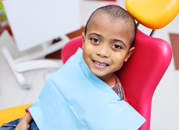 Cute black baby boy African American smiling sitting in the dental chair 