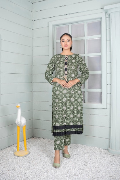 Photo cute blushing girl wearing traditional green kurta pajama for indoor fashion shoot