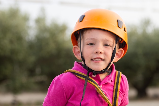 Cute boy enjoying a sunny day in a climbing adventure activity park. Boy at climbing activity in high wire forest park.