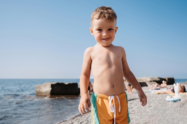 A cute boy is relaxing on the beach Outdoor activities on the seashore