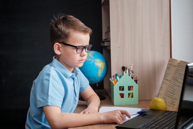 Cute boy takes an online education course at home