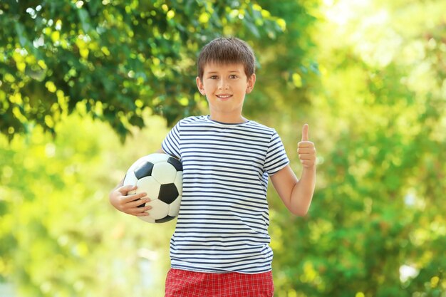 Photo cute boy with soccer ball in park